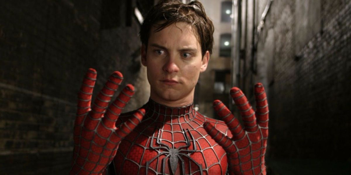 Tobey Maguire as Spider-Man staring at his hands without his mask