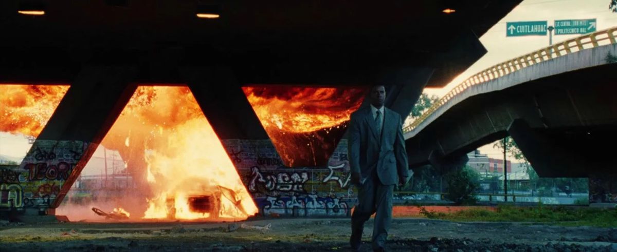 Creasy walks away from a burning car under an underpass in Man on Fire.