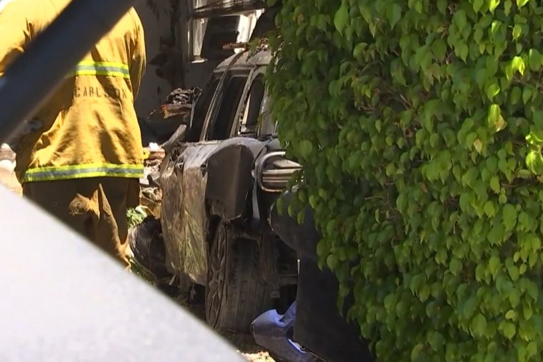 A firefighter works near the car believed to belong to Anne Heche after an accident Friday in Mar Vista, California.