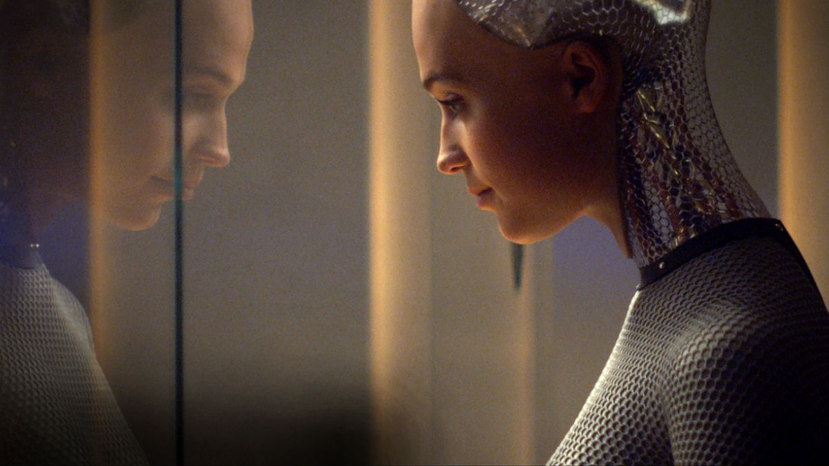 Alicia Vikander as Ava looking through glass at her own reflection in Ex Machina.