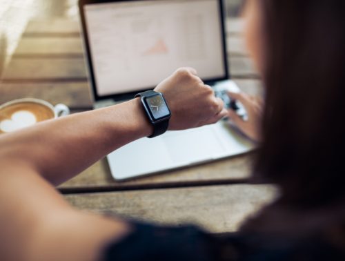 Close-up of a woman checking the time on her smartwatch. 